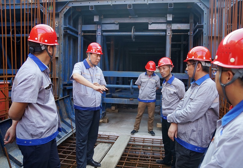 野外董事长在施工现场与项目部治理职员探讨管廊台车模板施工工艺